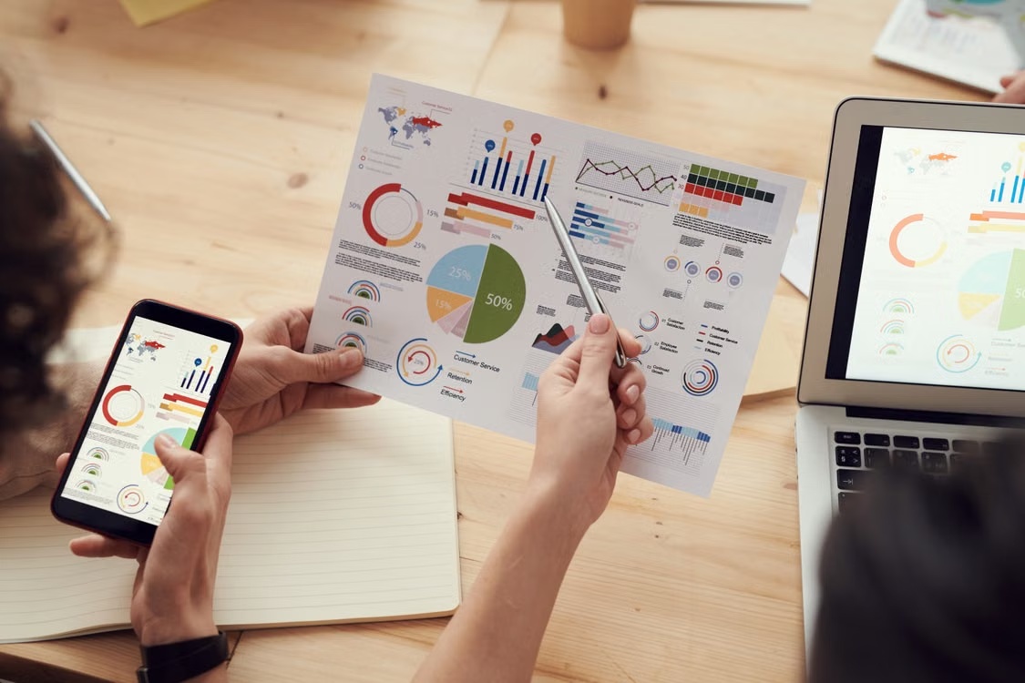 People reviewing charts and market research at a desk
