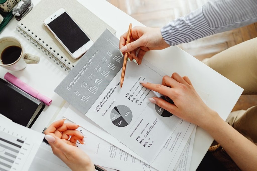 Hands reviewing printed research charts at a bright desk